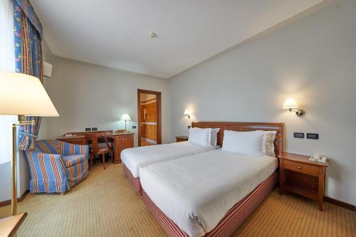 a hotel room with a bed and a desk at Relais Santo Stefano in Sandigliano