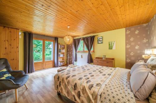 sypialnia z łóżkiem i drewnianym sufitem w obiekcie Chene Rouge w mieście Lapoutroie
