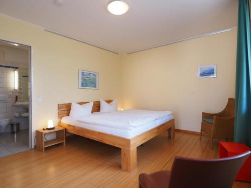 ein Schlafzimmer mit einem Bett in einem Zimmer in der Unterkunft Kaiservillen Heringsdorf - Ferienwohnung mit 1 Schlafzimmer und Balkon D134 in Heringsdorf