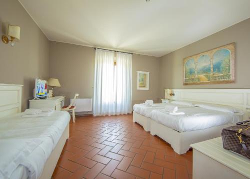 a hotel room with two beds and a window at HC Hotel Il Gelso Pontevico in Pontevico