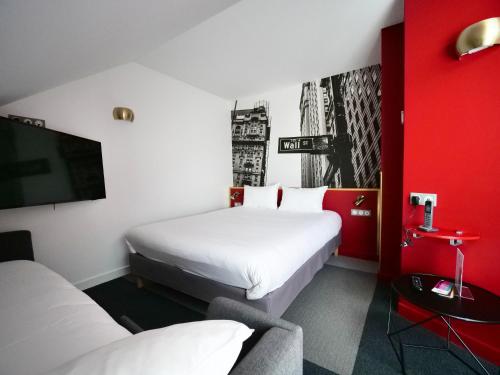 a hotel room with two beds and a flat screen tv at ibis Styles Chartres Métropole in Chartres