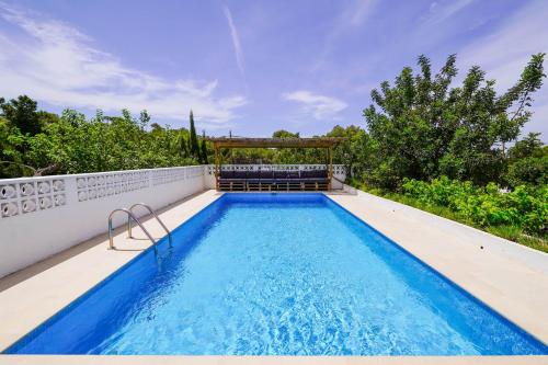 - une piscine avec un kiosque sur le côté d'une maison dans l'établissement Villa Geckos Charming holiday finca 5 min by car to the fabulous Cala Salada beach, à Sant Antoni de Portmany