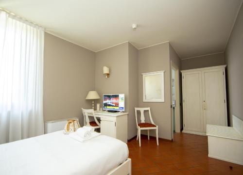 um quarto com uma cama e uma secretária com um computador em Hotel Il Gelso em Pontevico