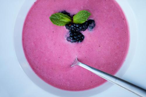 a fruit smoothie with a blackberry on a pink plate at Longevity Health & Wellness Hotel - Adults Only in Alvor