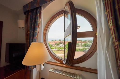 a round window in a room with a lamp at Relais Santo Stefano in Sandigliano