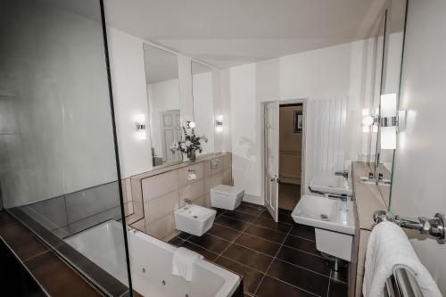 a bathroom with two sinks and two mirrors at York Pavilion Hotel, Sure Hotel Collection by Best Western in York
