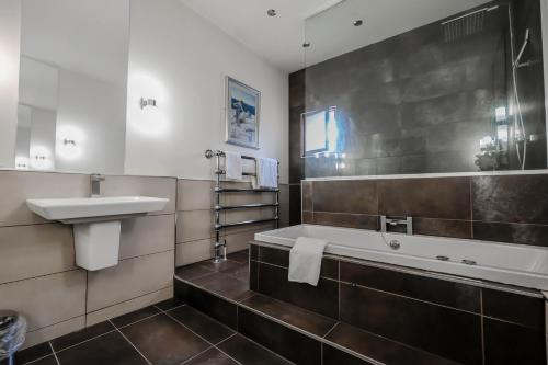 a bathroom with a sink and a bath tub at York Pavilion Hotel, Sure Hotel Collection by Best Western in York