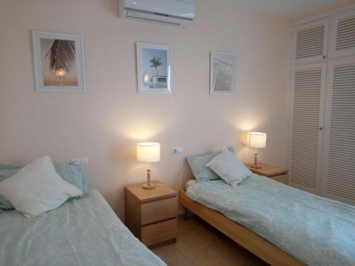 2 Betten in einem Zimmer mit 2 Lampen an Tischen in der Unterkunft Vallibre apartments in Cala d´Or