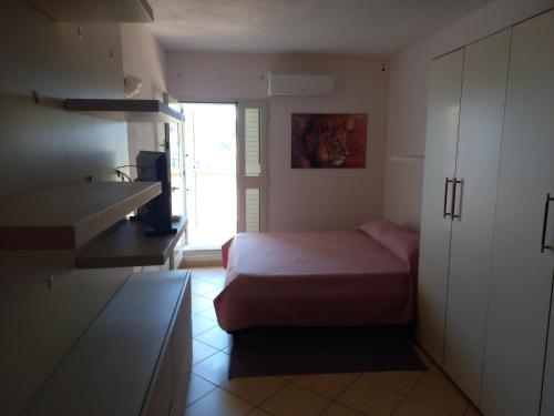 オルビアにあるCasa Coccoの小さなベッドルーム(ベッド1台付)、キッチンが備わります。