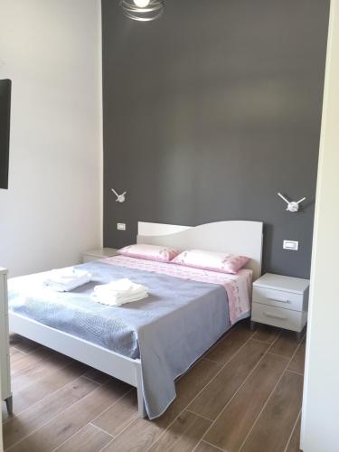 Habitación blanca con cama con almohadas rosas en Come nelle Favole, camere e appartamenti en Castellabate