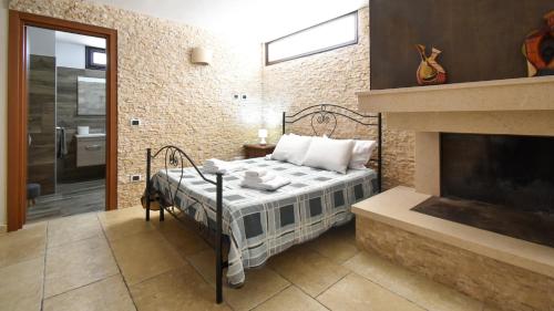 1 dormitorio con 1 cama y chimenea en Casa Carlà by Rentbeat, en Surbo