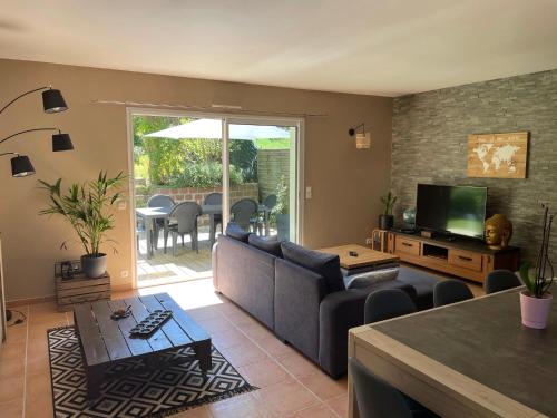 ein Wohnzimmer mit einem Sofa und einem Tisch in der Unterkunft Maison au cœur du Pays Basque in Cambo-les-Bains
