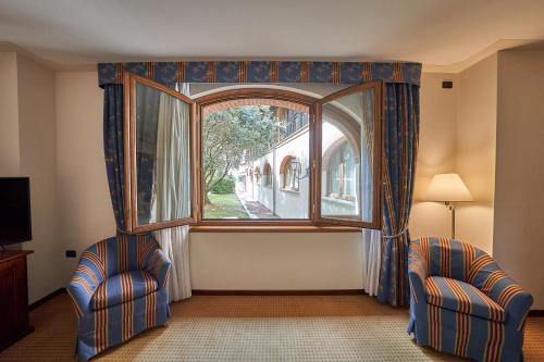 a room with two chairs and a large window at Relais Santo Stefano in Sandigliano