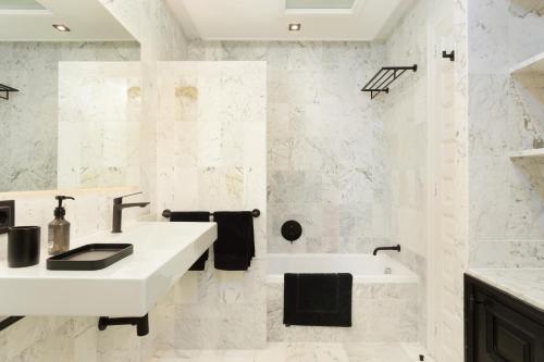 a white bathroom with a sink and a tub at SA GUARDA in Llafranc