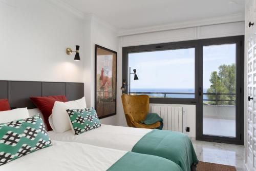 a bedroom with a bed and a large window at SA GUARDA in Llafranc