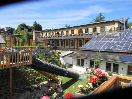 Blick auf einen Spielplatz mit Wasserrutsche und ein Gebäude in der Unterkunft Ferienanlage Markus Nitsch in Bärenstein