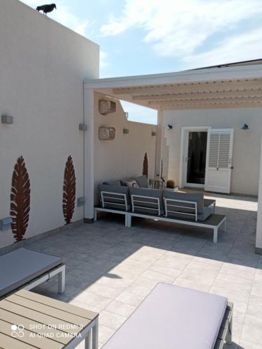 a patio with two benches and a couch on it at Catria in Favignana