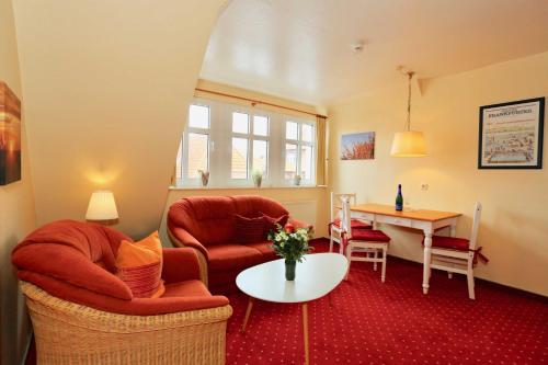 ユイストにあるInselresidenz Strandburg - Ferienwohnung 303 (Ref. 50971)のリビングルーム(赤いソファ、テーブル付)