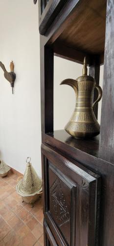 a group of vases sitting on top of a wooden cabinet at Dar Salam Palm - Guest Choice Award 2024 in Marrakech
