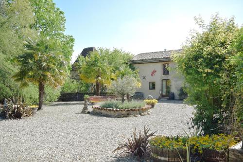 a garden with a bench and trees and a building at Le Hibou @ Le Prielle in Madiran