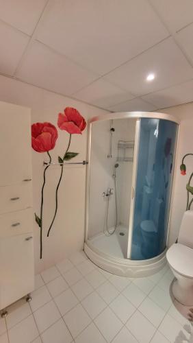La salle de bains est pourvue d'une douche avec des fleurs rouges sur le mur. dans l'établissement Vallikraavi Home, à Tartu