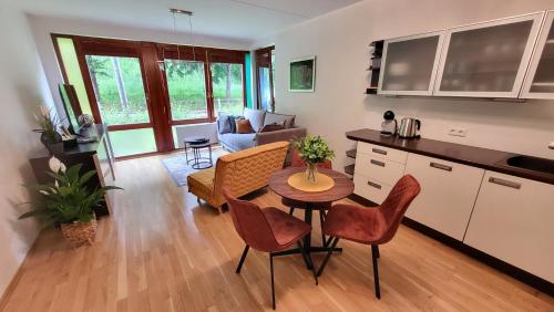 Il comprend une cuisine et un salon avec une table et des chaises. dans l'établissement Vallikraavi Home, à Tartu