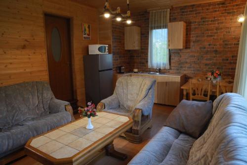 un soggiorno con divani e un tavolo e una cucina di Cottage Woodside a Mestia