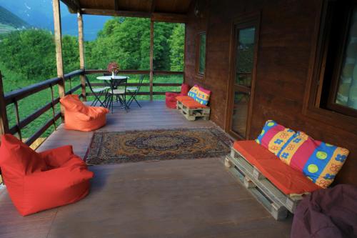 un portico di una cabina con sedie e un tavolo di Cottage Woodside a Mestia