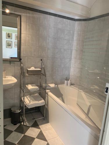 a bathroom with a bath tub and a sink at Chambres d'hôtes Maison Redon in Tour-de-Faure
