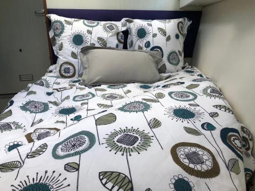 - un lit avec une couette et des oreillers blancs et bleus dans l'établissement Le bateau du Foudre, à Châtillon-en-Bazois