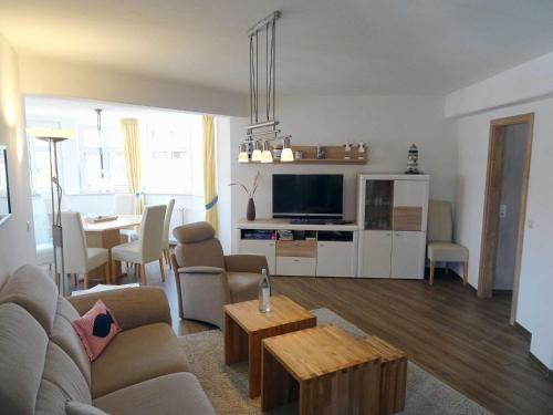 ein Wohnzimmer mit einem Sofa und ein Wohnzimmer mit einem Tisch in der Unterkunft Inselresidenz Strandburg Juist - Turmwohnung 205 (Ref. 50959) in Juist