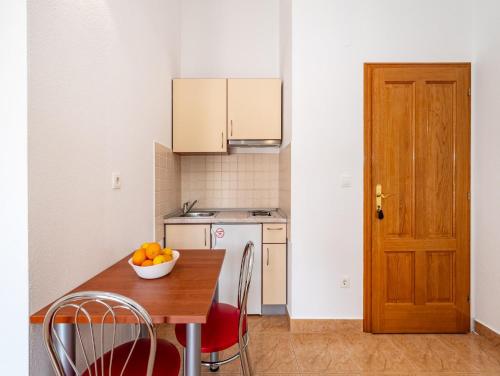 a kitchen with a table with a bowl of fruit on it at Apartments Prkačin in Starigrad-Paklenica