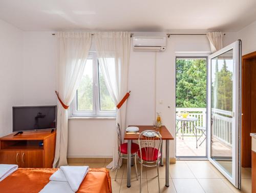 a bedroom with a bed and a desk and a window at Apartments Prkačin in Starigrad-Paklenica