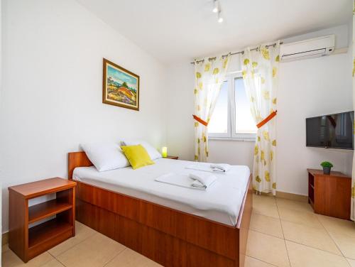 a bedroom with a large bed and a television at Apartments Prkačin in Starigrad-Paklenica