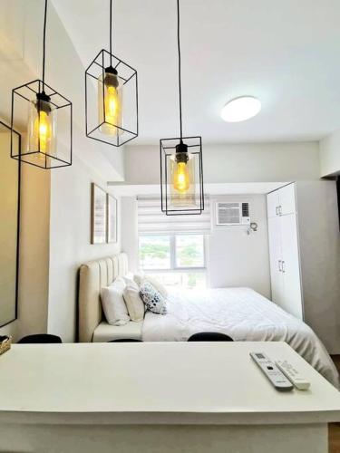 a bedroom with a bed and a couch and lights at Steff's Condo 815 at CENTRIO Tower Deluxe Unit in Cagayan de Oro