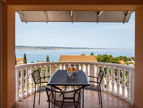 a table on a balcony with a view of the ocean at Apartments Prkačin in Starigrad-Paklenica