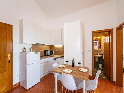 a kitchen with a wooden table and white appliances at Apartments Prkačin in Starigrad-Paklenica