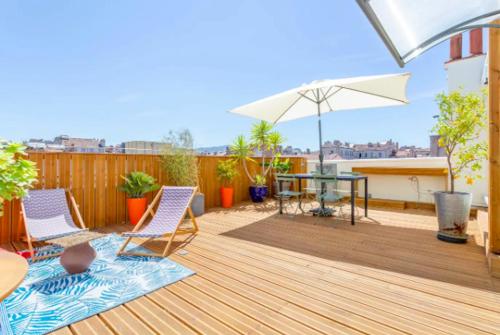 un patio avec une table, des chaises et un parasol dans l'établissement STUDIO ** ROOFTOP ** LULLI, à Marseille