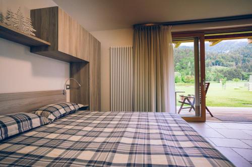 una camera con letto e porta scorrevole in vetro di Chalet Valcanale a Camporosso in Valcanale