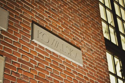 a sign on the side of a brick building at Hotel Pod Lwem in Elblag