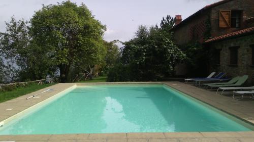 a swimming pool in front of a house at Holiday home Belvedere in Montevarchi