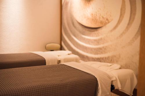 two beds in a room with a painting on the wall at Karpaz Gate Marina Hotel in Ayia Trias