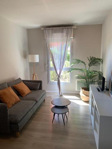 a living room with a couch and a table in front of a window at Apparteo Marseille in Marseille