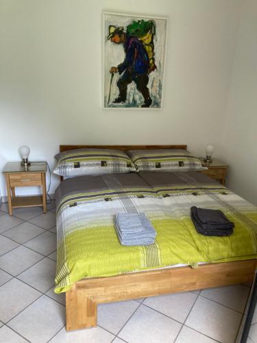 a bedroom with a large bed with a yellow blanket at Cà Maria in Bignasco