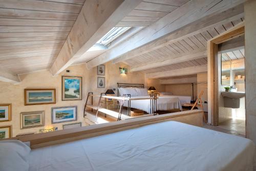 a bedroom with a large bed and a room with a bed sqor at Casa Ferret. Appartamento nel cuore di Alghero in Alghero