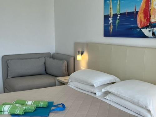a bed with two pillows and a couch in a room at Alba D'Amore Hotel & Spa in Lampedusa