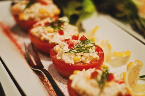 un plato de comida con tomates y un tenedor en Hotel Pod Lwem, en Elbląg
