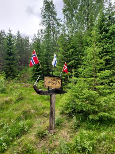 a sign in the middle of a field with flags at The Old Logging Camp in Yttermalung
