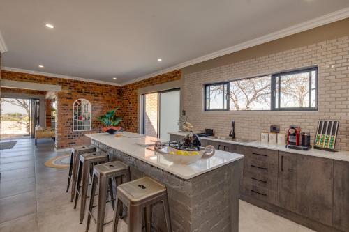 una cocina con una gran isla con taburetes de bar en HAVANA VILLA - Pretoria East Luxury Villa en Pretoria