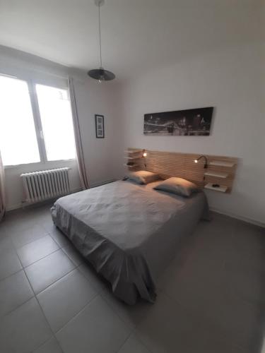 a bedroom with a large bed and two windows at Villa " Les Bambous " , Jardin , Terrasse , Climatisation , Wifi , Parking in Avignon